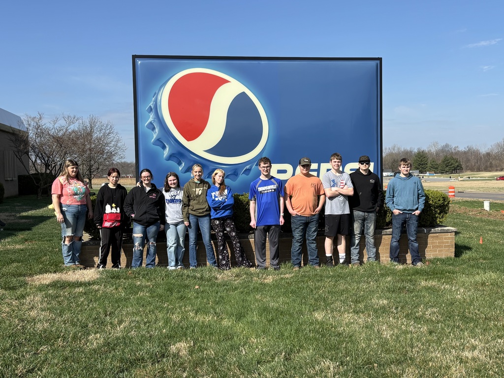 Students pose with the sign