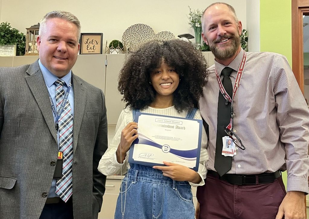 student holding up certificate