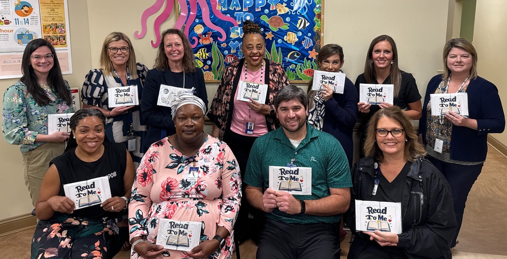 People standing with Read to Me literacy packet