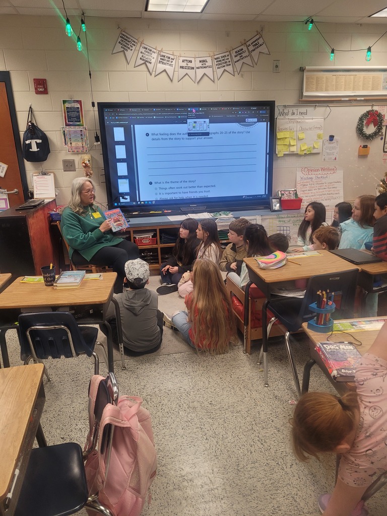 A grandparent reading to Mrs. Overman's 3rd grade class at Omega Elementary School.