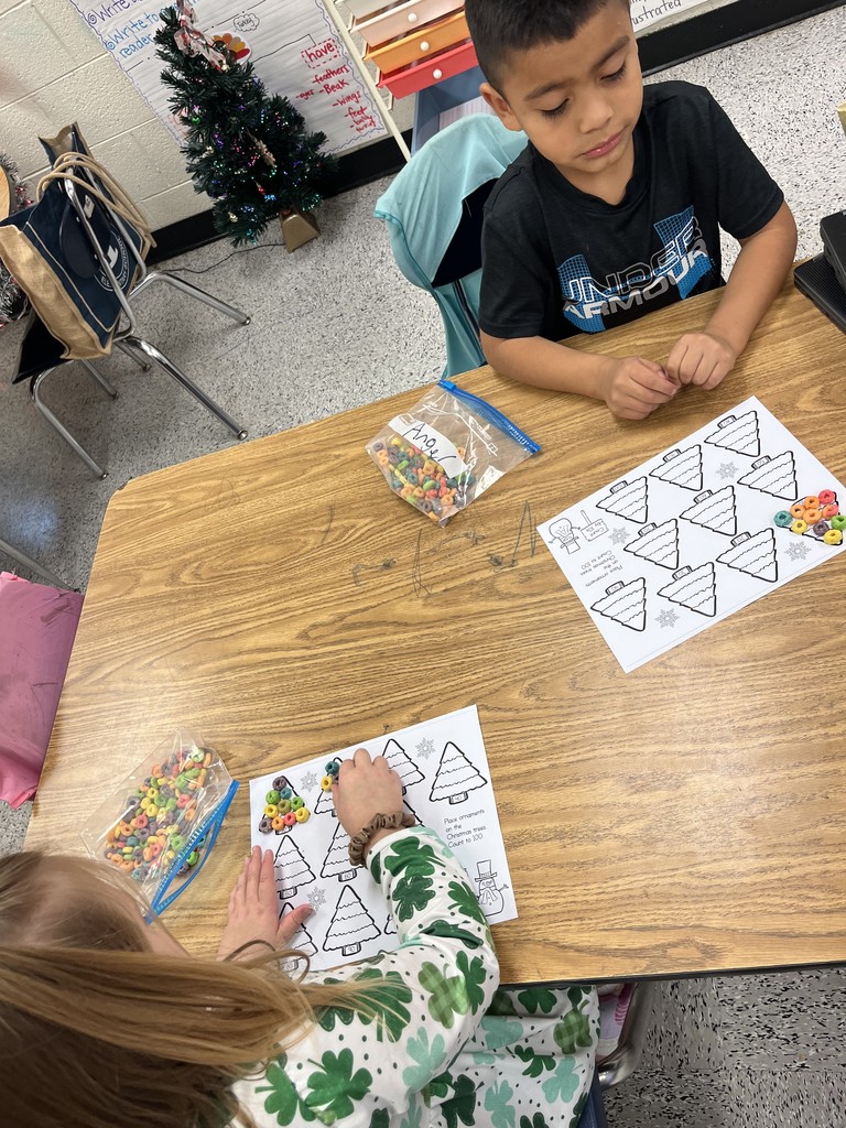 Kindergarten students practice counting by tens with Christmas trees.