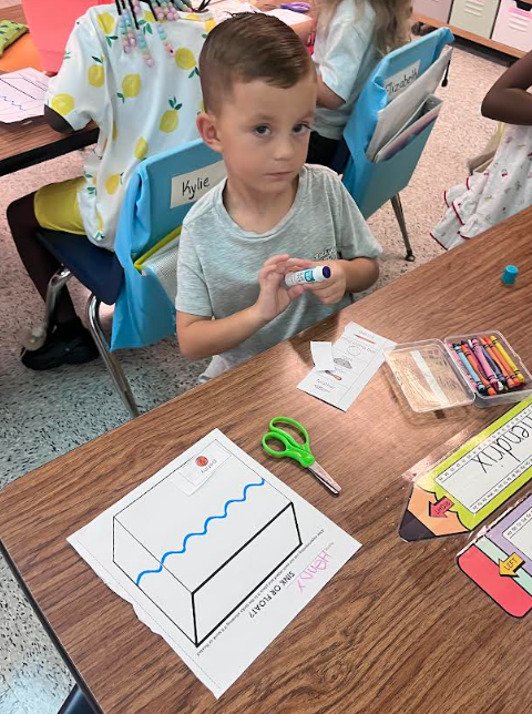 Mrs. Webster's Kindergarten class cutting and gluing and making predictions.