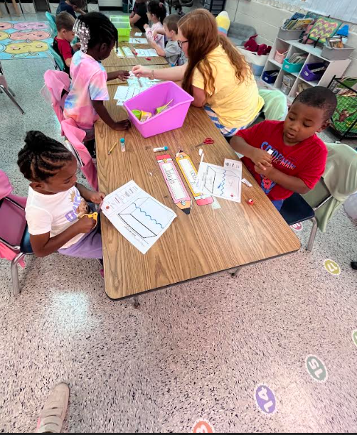 Mrs. Webster's Kindergarten class cutting and gluing and making predictions.