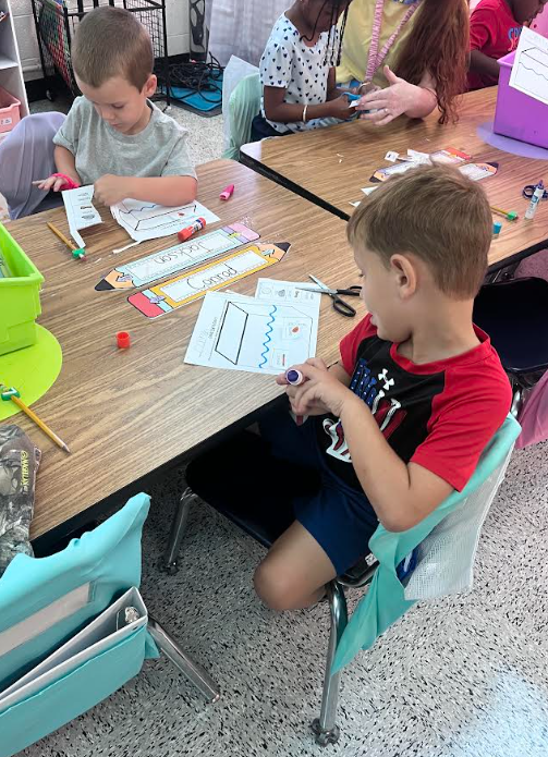 Mrs. Webster's Kindergarten class cutting and gluing and making predictions.