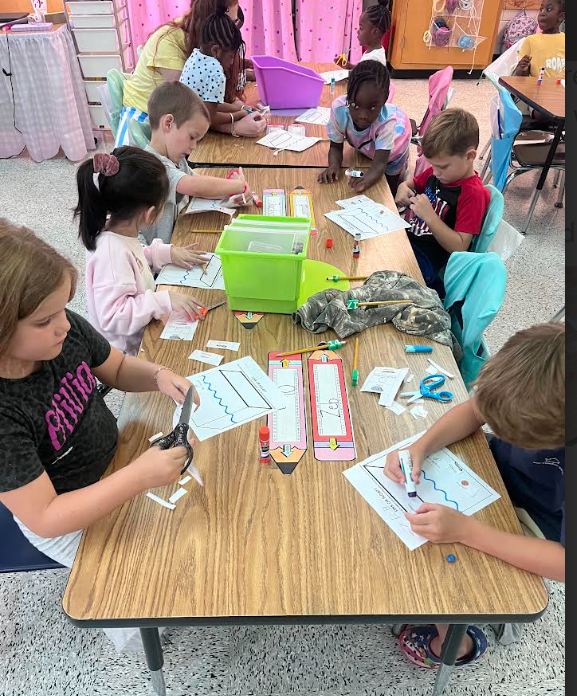 Mrs. Webster's Kindergarten class cutting and gluing and making predictions.