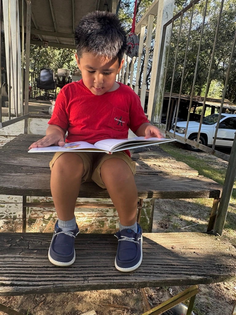 Omega Elementary School students reading at home. 