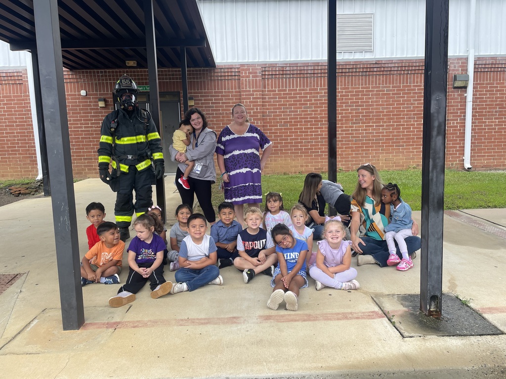 Students with a firefighter after learning about community helpers. 