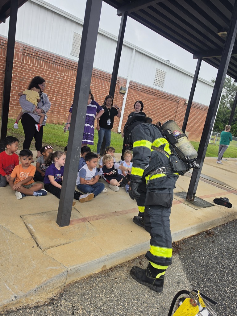 Students with a firefighter after learning about community helpers. 