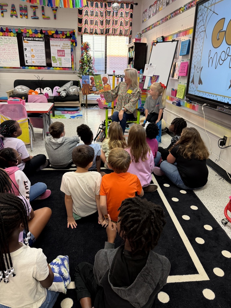 Mrs. Cromer reads to Mrs. Spurlin's second grade class.