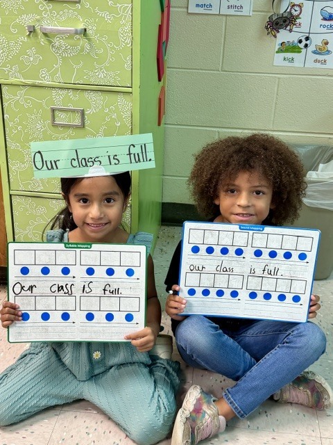 Students wearing headbands to practice sentence writing.