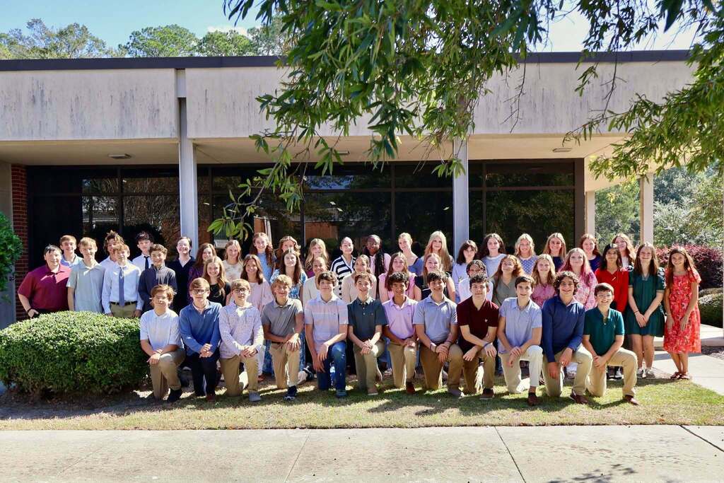 Students representing Eighth Street Middle School, Northeast Middle School, and Tiftarea Academy pose for a group photo outside the Tifton-Tift County Chamber of Commerce during the kickoff event for the 2026–2027 Emerging Young Leaders Program. Students are arranged in several rows, with some kneeling in front and others standing behind them.