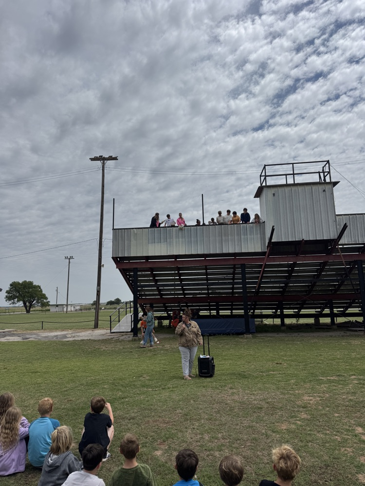 students watching the 6th graders drop their egg drop contraptions from the grand stands  