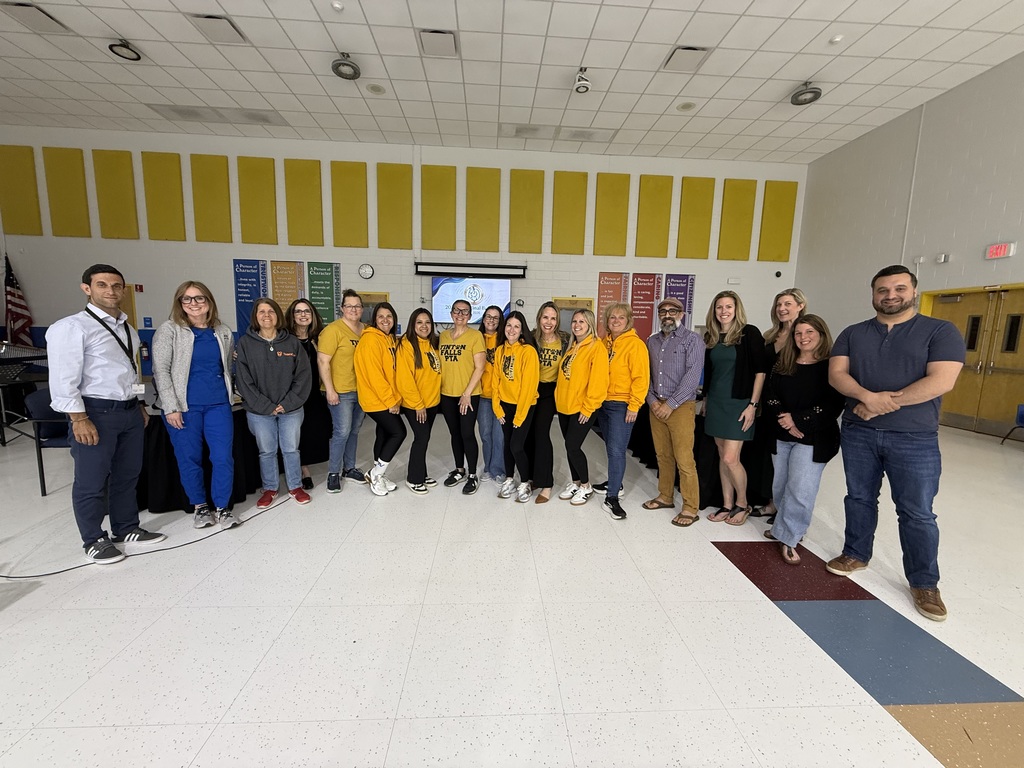 Group of people representing the board and PTA standing in a school cafeteria
