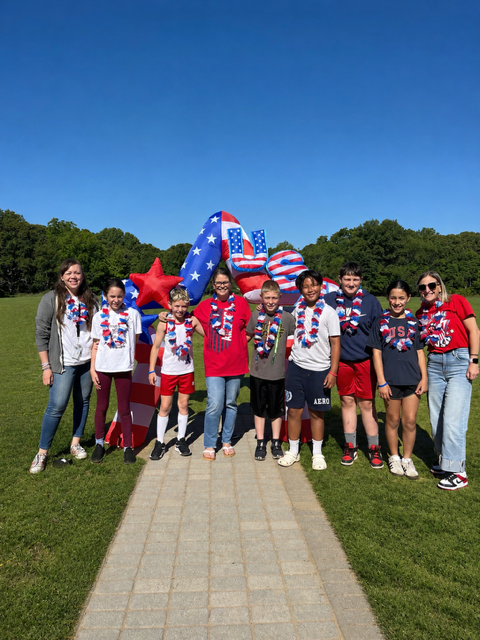 Students and teachers standing in front of USA ballon for America's 250th birthday celebration