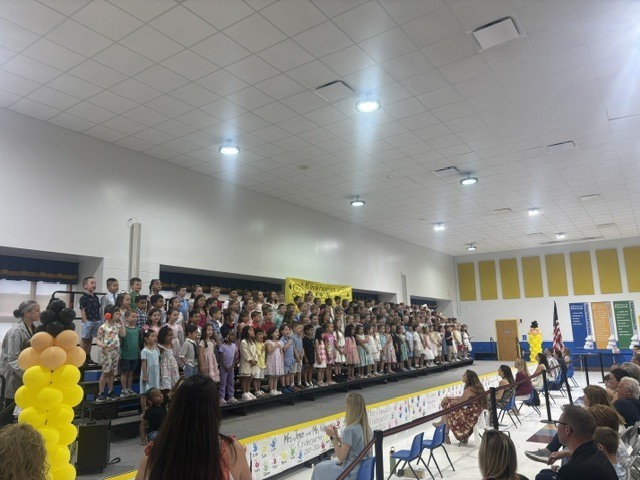 Kindergarten students on a stage singing