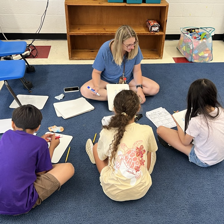teacher sitting with two students  