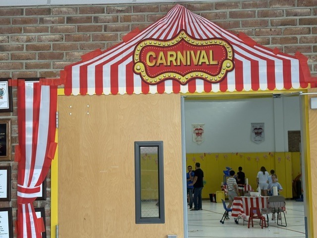 Sign that says carnival outside the  door of the gym. 