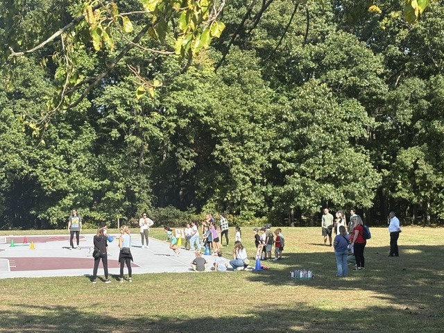 A field with children, parents and teachers participating in field day