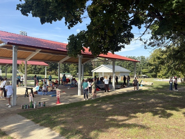 A pavillion with children, parents and teachers participating in field day