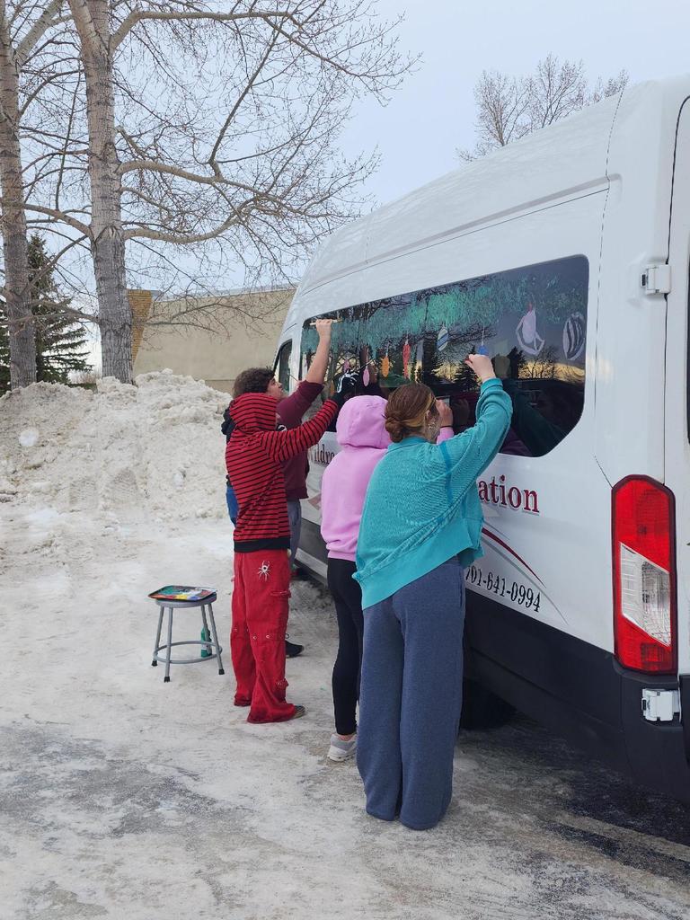 Art I students painting the Wildrose bus for the Holidays
