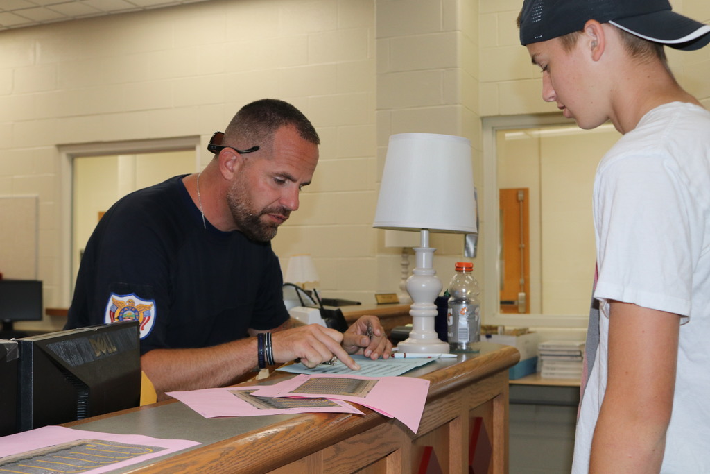 Officer Phil Osting with a student getting a parking pass.