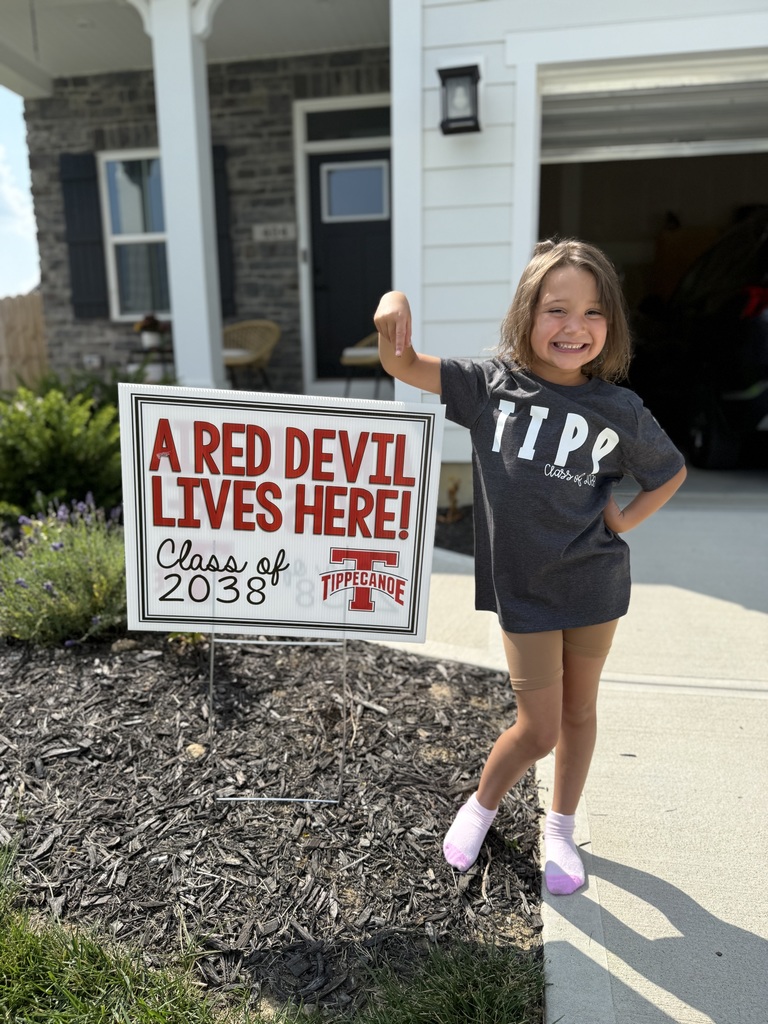 Kindergarten student standing with the yard signing saying A Red Devil Lives Here!