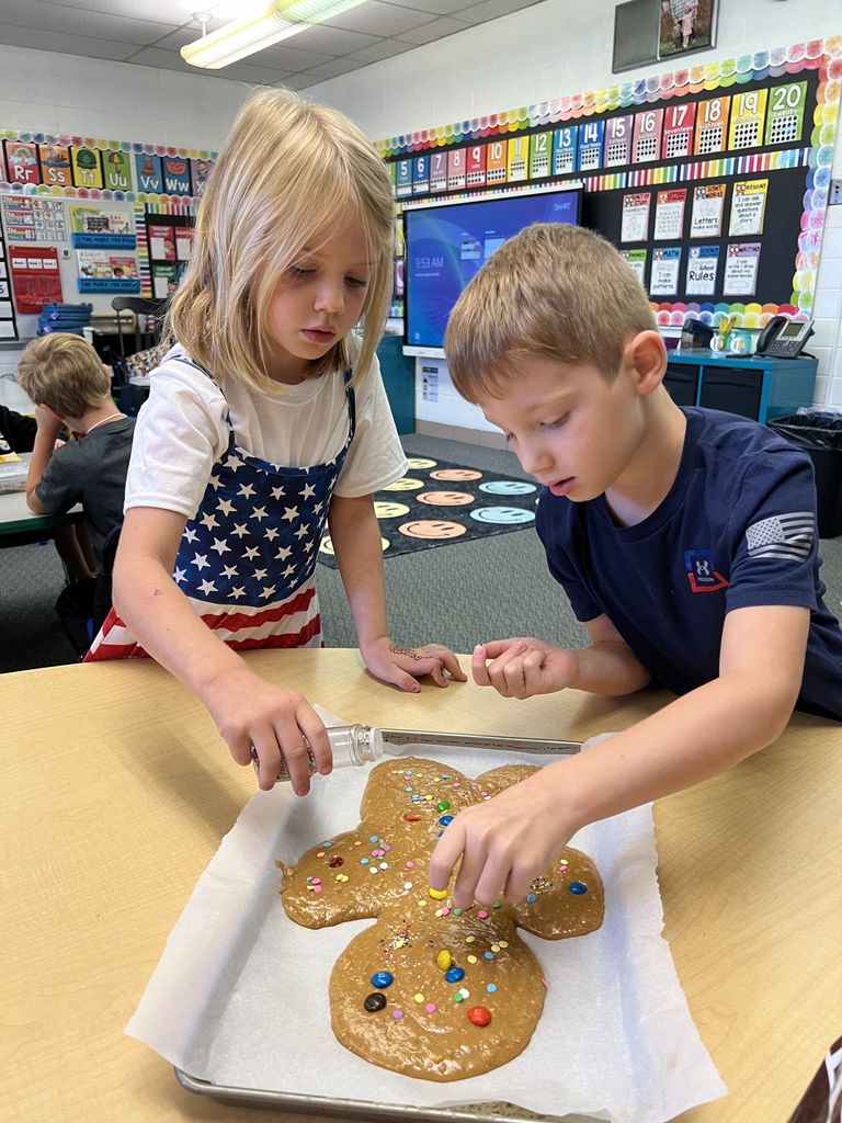 Students are decorating a large cookie.