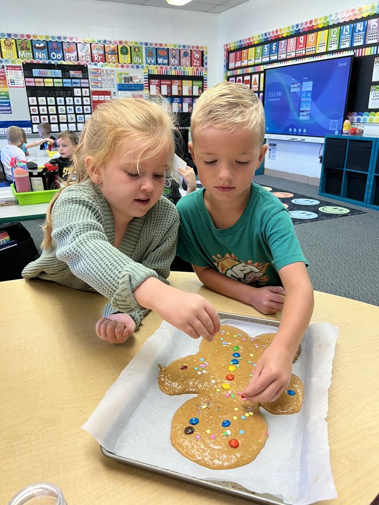 Students are decorating a large cookie.