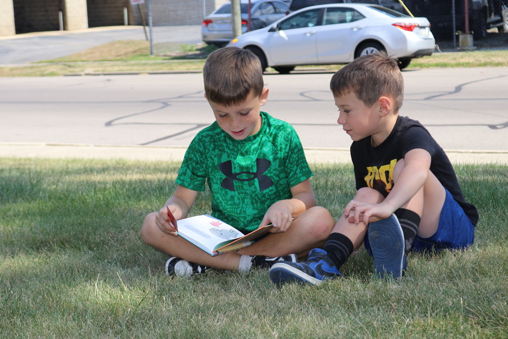 Students reading on the lawn during a visit from Tipp City Public Library.