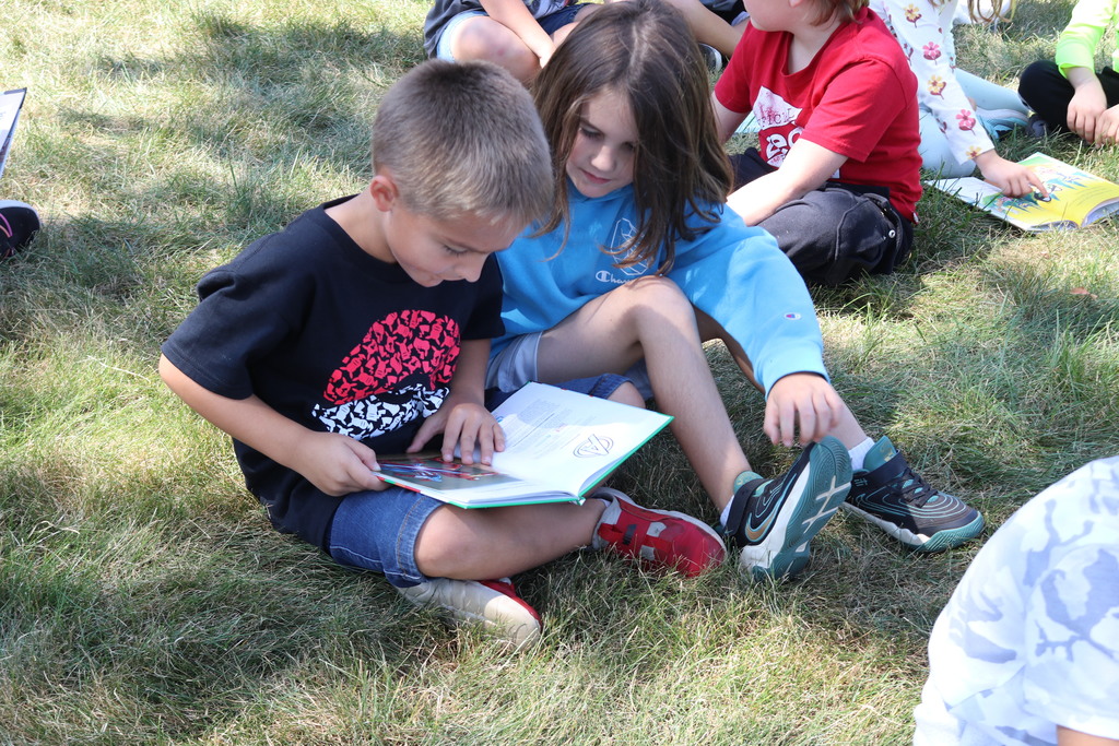 Students reading on the lawn during a visit from Tipp City Public Library.