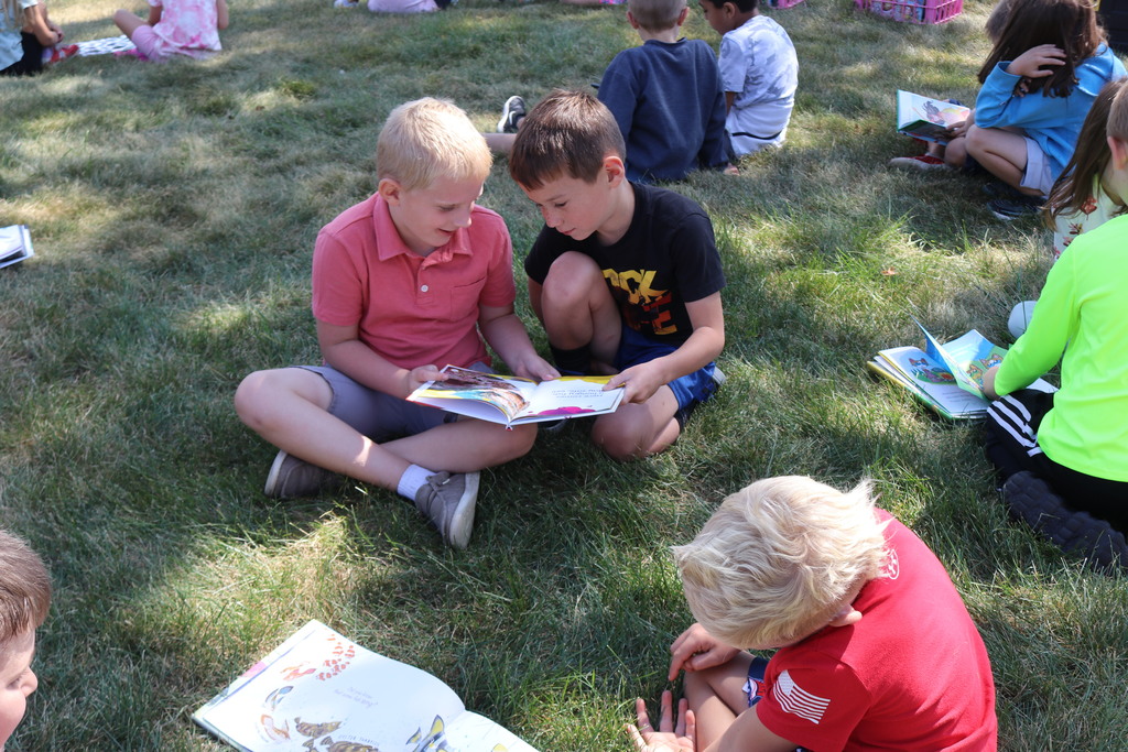 Students reading on the lawn during a visit from Tipp City Public Library.