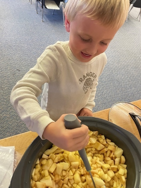 First graders made applesauce to celebrate Johnny Appleseed's birthday.