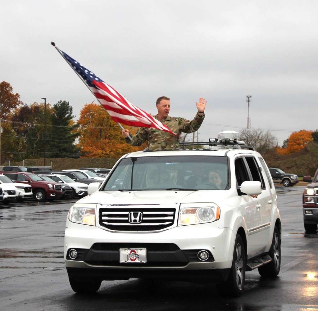 A member of the military proudly waves the American flag as he drives through the Parade of Heroes at L.T. Ball Intermediate School.