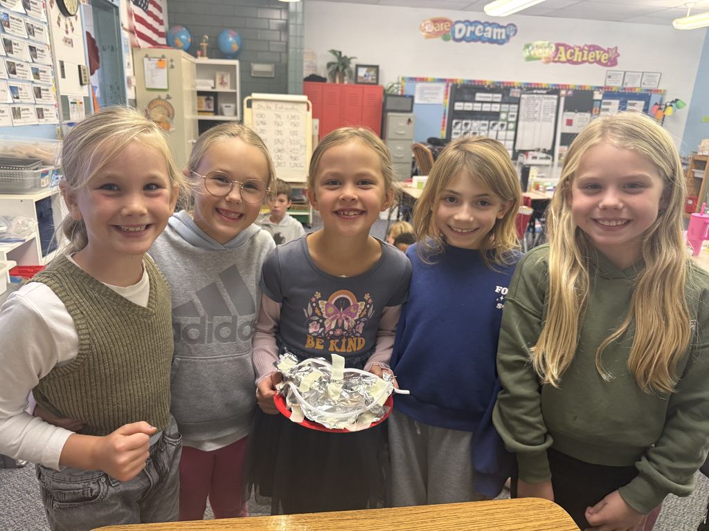 Broadway students learn about the strugglers of early settlers and pose with their project.