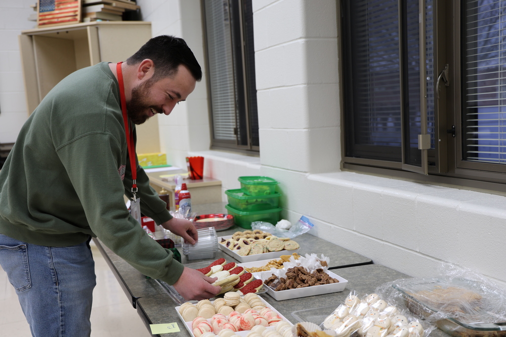 A staff member is selecting his cookies with a huge smile. 