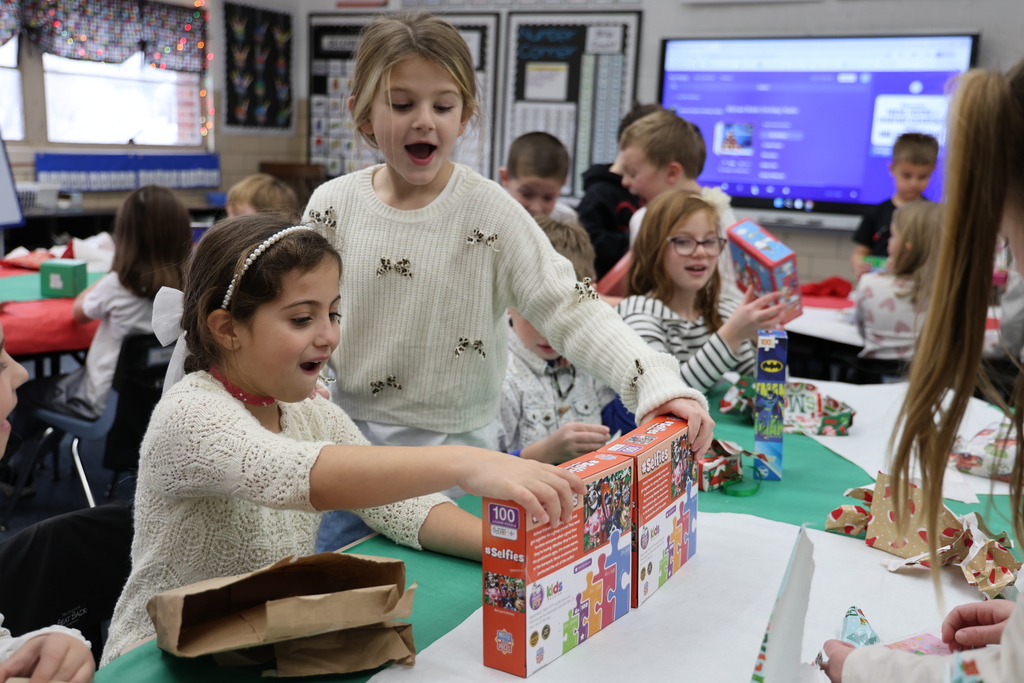 First graders show excitement during their puzzle gift exchange.