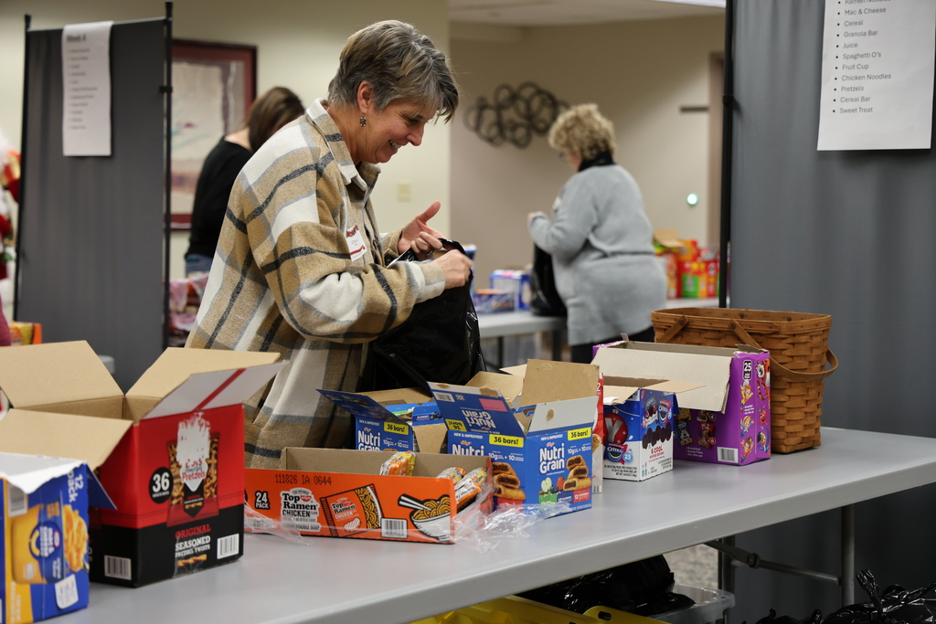 A volunteer fills a food bag.