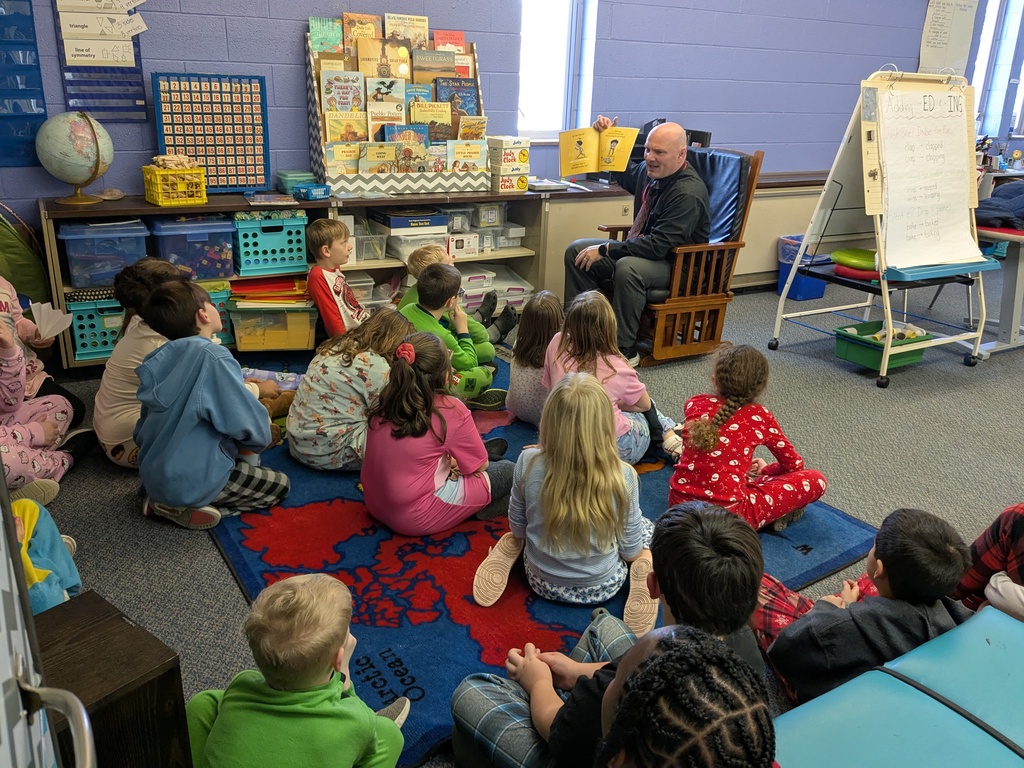 Second graders in Mrs. Black's class listen to the district's superintendent as he reads them a story.