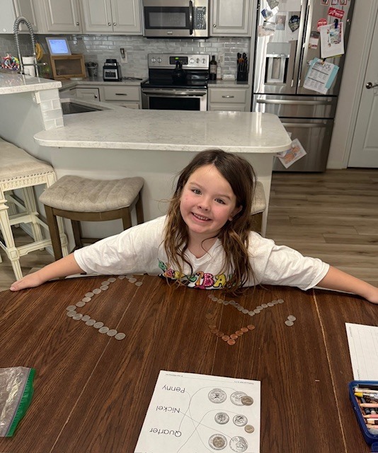 A student is counting and sorting money during the Online Learning Day.