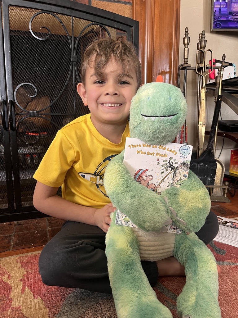 A student is reading with his stuffed animal during the Online Learning Day.