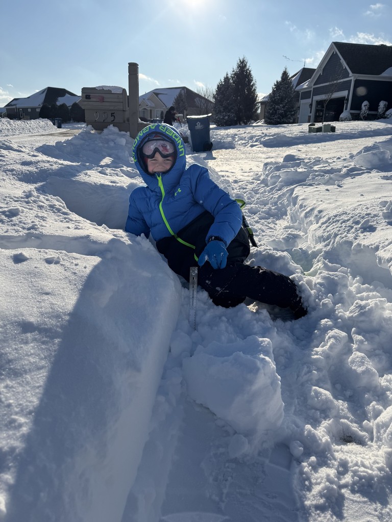 A student is measuring snow during the Online Learning Day..