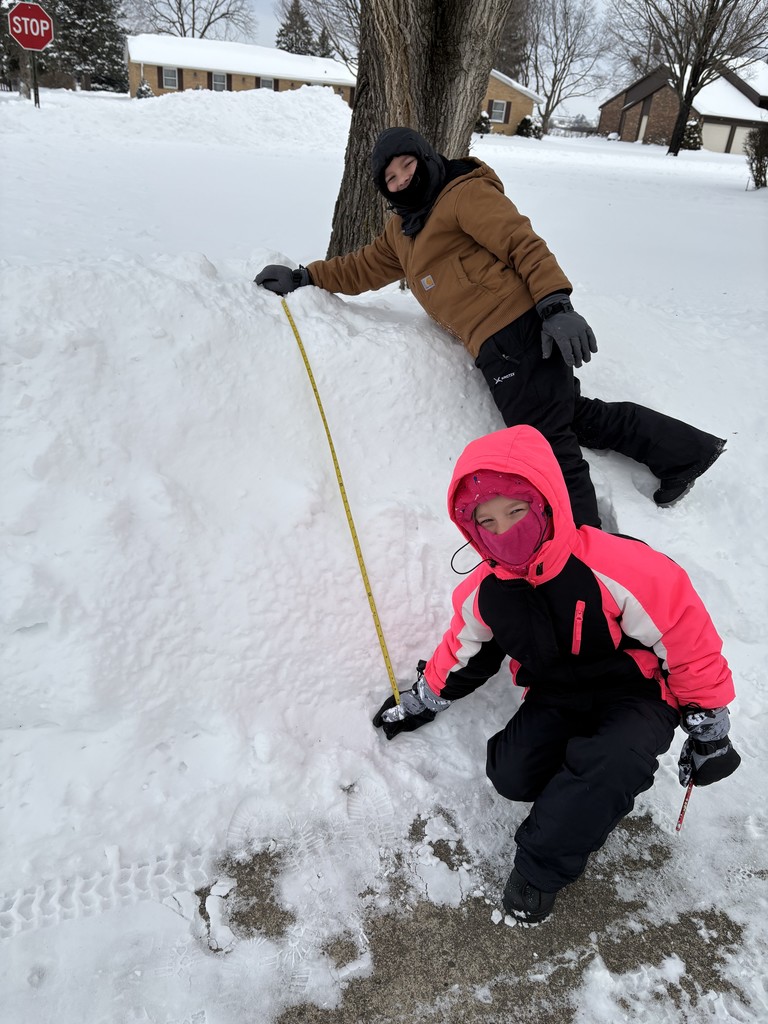 Students are outside measuring snow and distances.