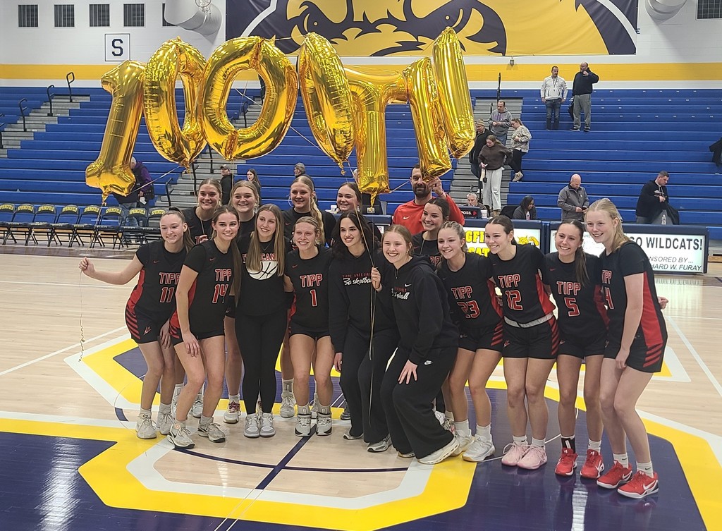 Picture of the THS basketball team with balloons spelling 1000th.