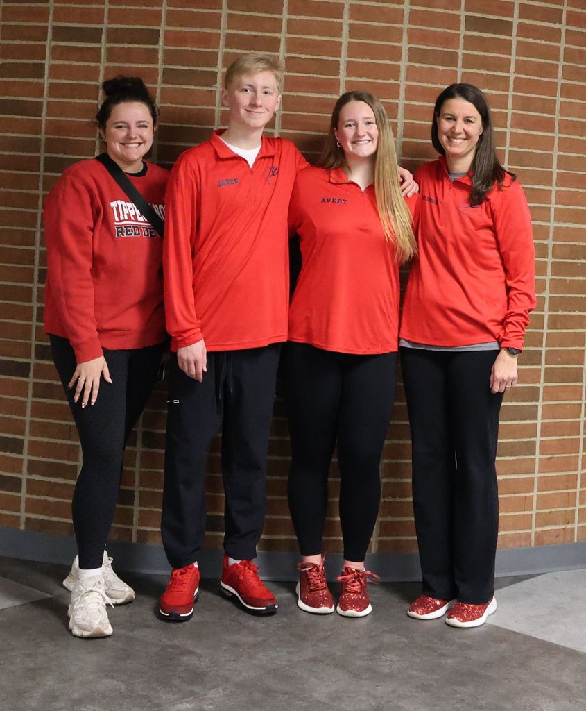 Avery and Jaxen Anderson pose for a photo with their coaches.