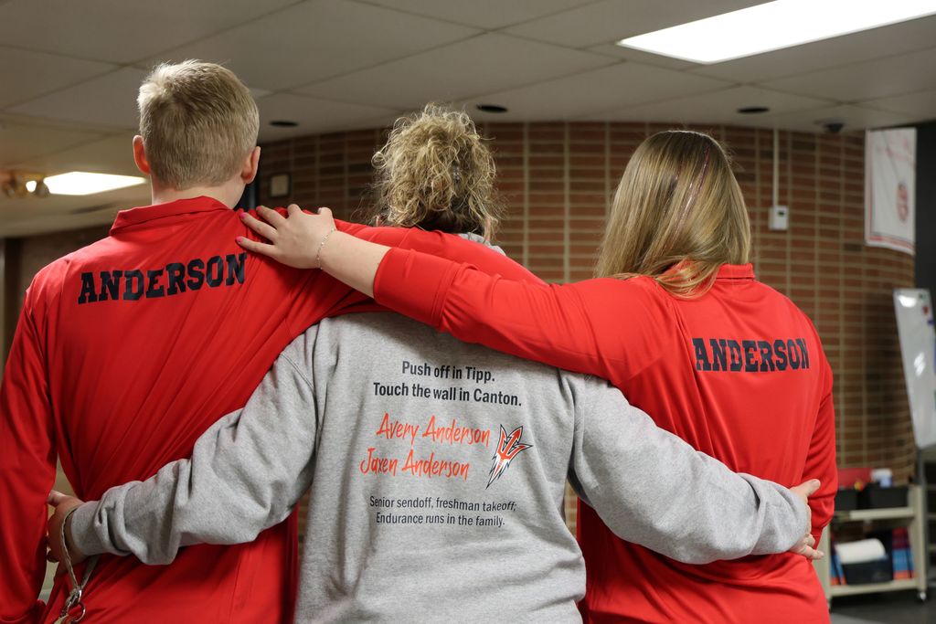 The backs of the Anderson family sweatshirts with their names.  Mom's sweatshirt say Push off in Tipp.  Touch the Wall in Canton and it has her kids' names on it.  