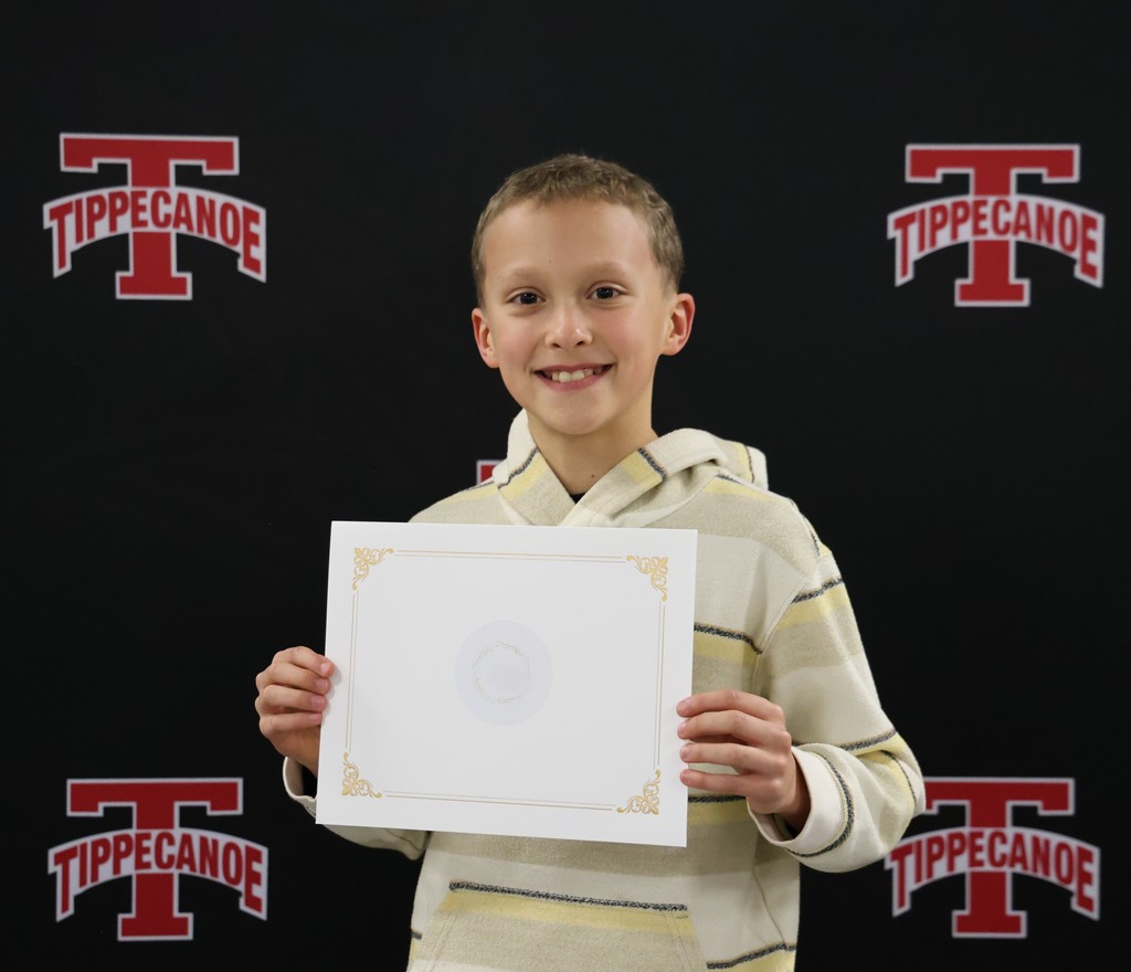 A photo of an L.T. Ball student holding his certificate for being recognized at a BOE meeting.