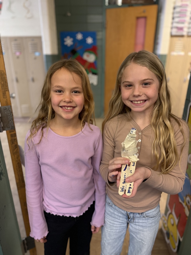 Students show off their skier made out of foil as part of a stem project on speed and motion.