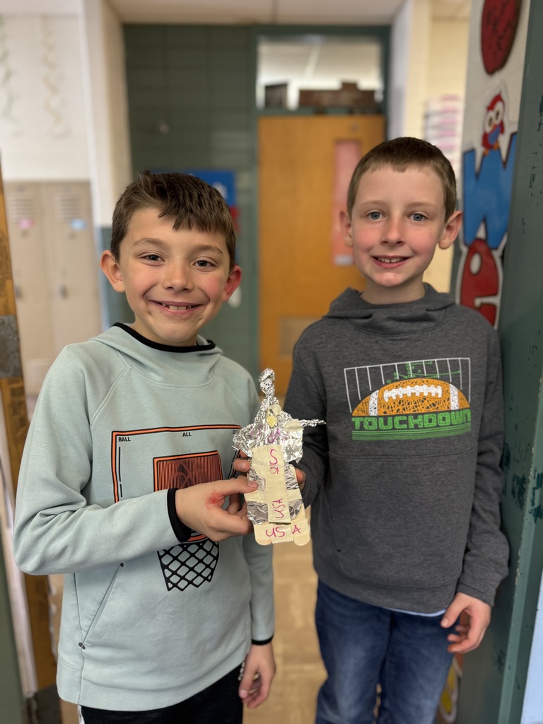 Students show off their skier made out of foil as part of a stem project on speed and motion.