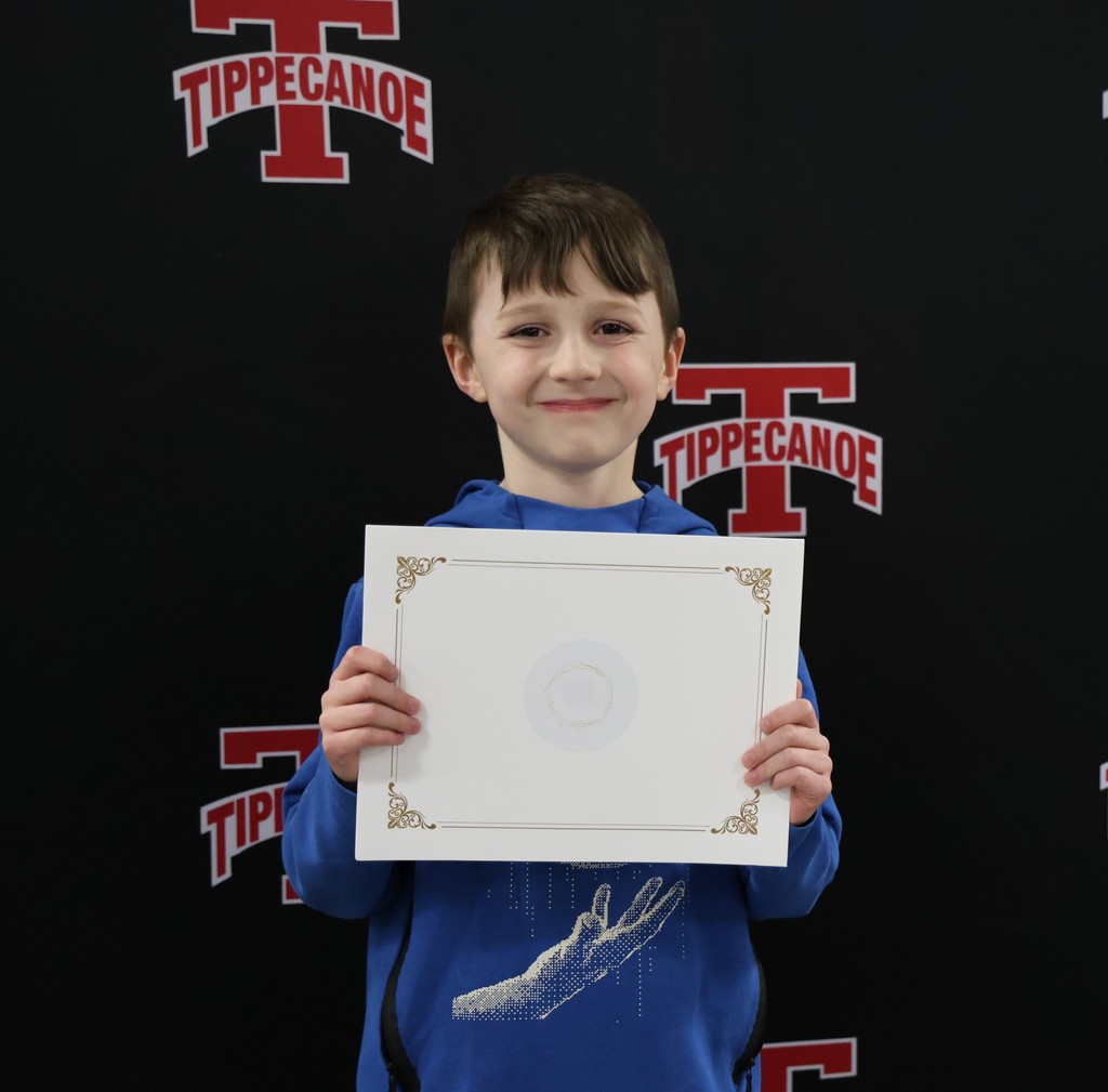 Broadway Elementary student holding his certificate from the district.  