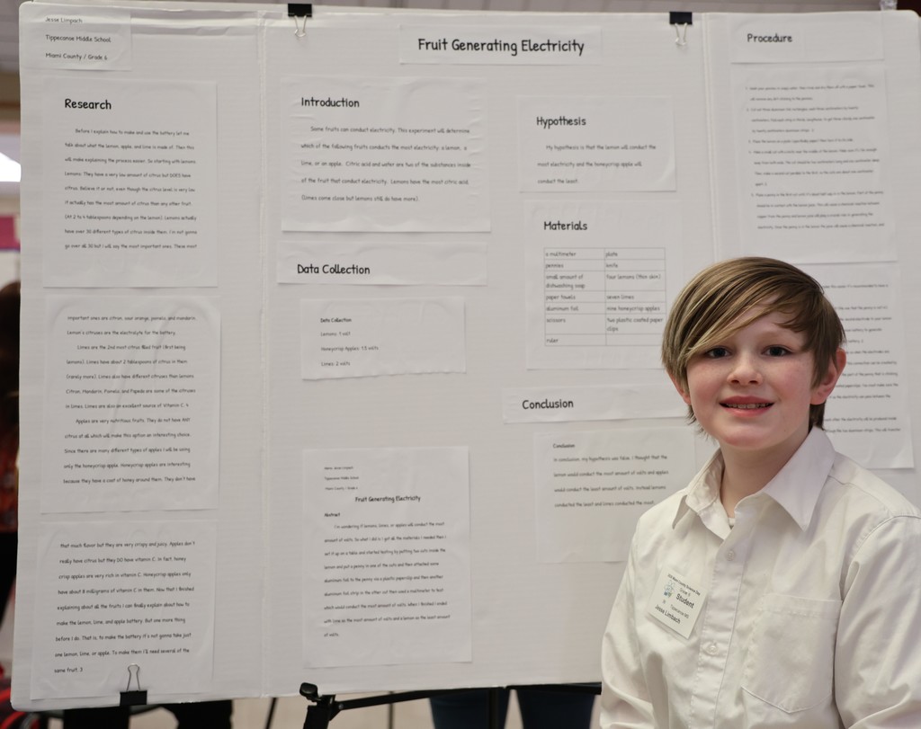 TMS students proudly stands with his project at Miami County Science Day.